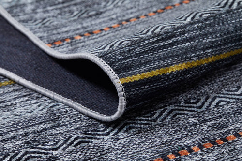 Load image 1 in gallery view. A close-up of the Metro Lines - Washable Rug - JR1548 (Custom Size) shows its textured flat weave, gray and black geometric patterns, vibrant yellow and orange stripes, and a folded corner revealing the backing and edge stitching.
