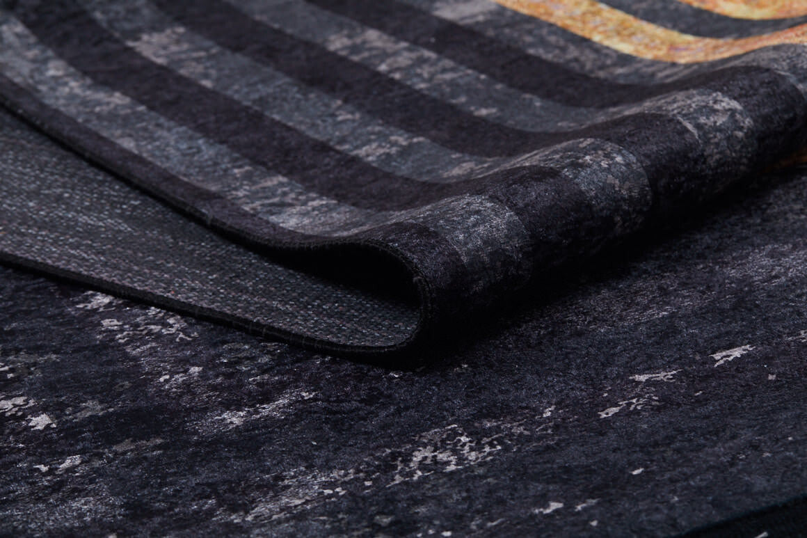A close-up of the Minimalist and Clean - Washable Rug - JR1407 (Custom Size) reveals its textured striped pattern in gray, black, and gold tones—perfect for high-traffic areas. The rug is slightly folded to show both surface and underside.
