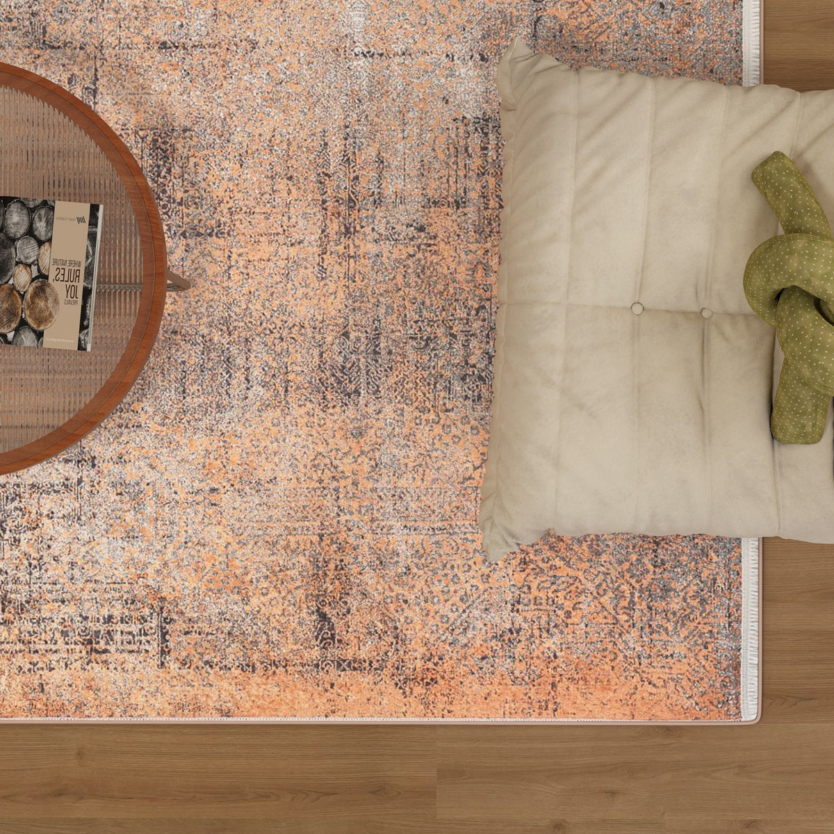 A top view of the Modern Mosaic - Machine-Washable Rug JR1846 (Custom Size) in peach and gray, styled with a beige floor seat, green knotted pillow, and round side table—ideal for high-traffic wooden floor areas.
