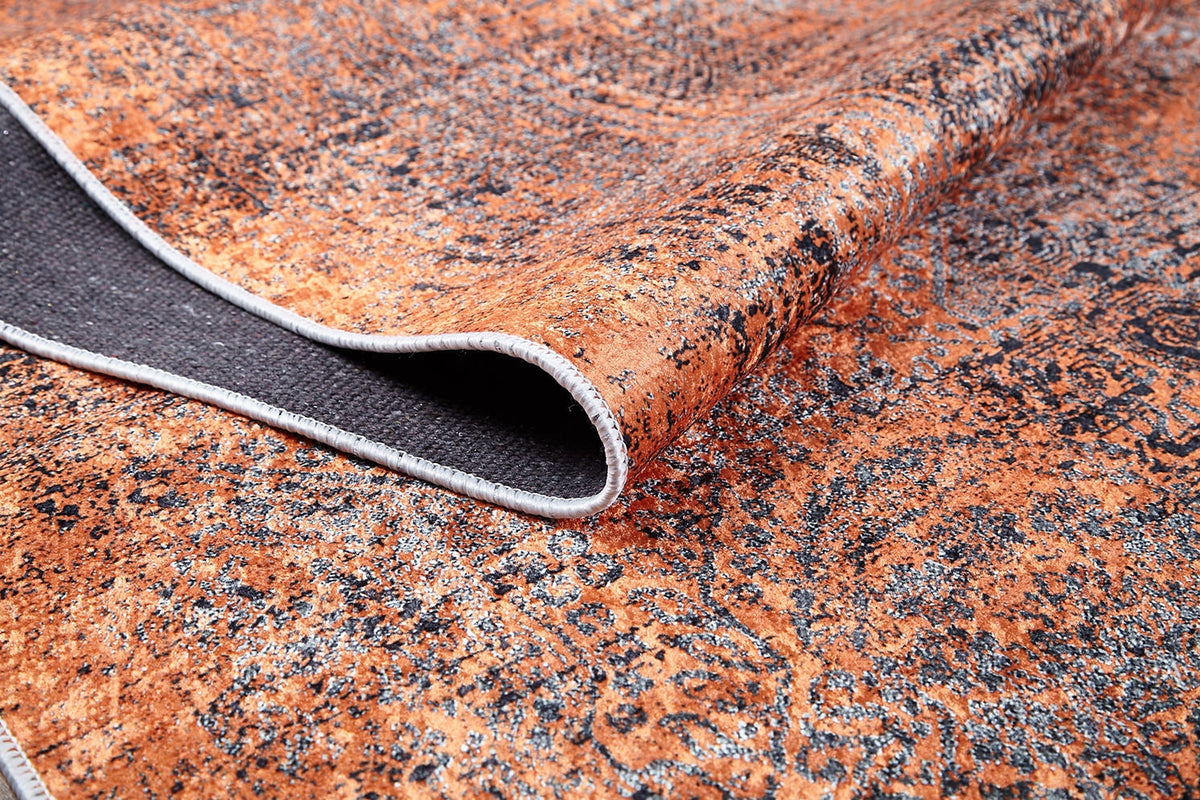 A close-up of the Modern Mosaic - Machine-Washable Rug JR1846 (Custom Size) reveals its brown and black pattern, contrasting dark backing, and stitched edge—perfect for high-traffic areas.