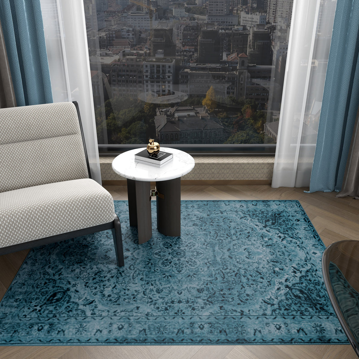 A modern room features the Mystic Mosaic - Washable Rug - JRN1019 (Custom Size) in blue, a white cushioned chair, a round white side table with decor, floor-to-ceiling windows with city views, and blue curtains.