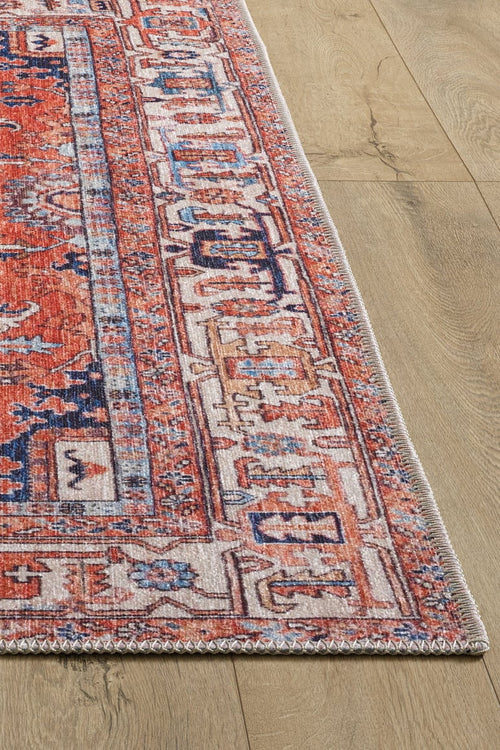 Load image 1 in gallery view. A close-up of the Mystral Kilim-Design Coral Washable Rug (LCC3015) shows its red, blue, and ivory geometric pattern on a light wood floor. The image highlights the rug’s corner and detailed border—ideal for high-traffic areas.