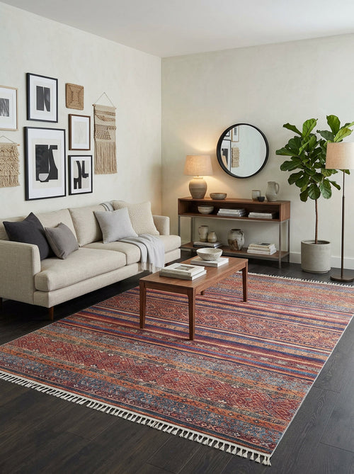Load image 1 in gallery view. Red and blue striped rug with intricate geometric patterns and fringe, styled in a modern living room.