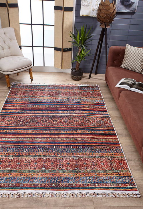 Load image 1 in gallery view. A living room featuring the Native Nightscape - Washable Rug - JR5093 (Custom Size) in multicolor on a wooden floor, paired with a brown sofa, beige tufted chair, potted plant, large windows with blinds, and décor against a gray wall. Perfect for high-traffic spaces.