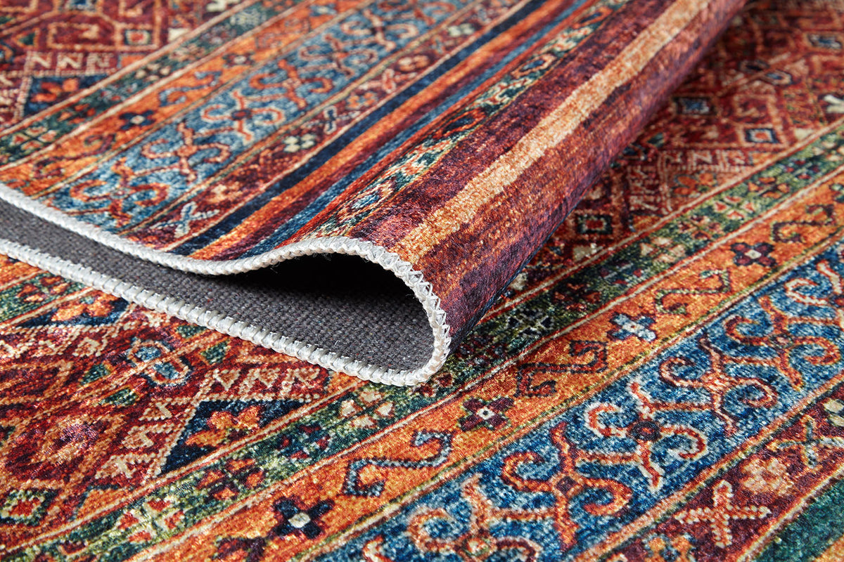 A close-up of the Native Nightscape - Washable Rug - JR5093 (Custom Size) highlights its vibrant multicolor geometric and floral patterns, with the lifted edge revealing a textured, durable underside—ideal for high-traffic areas.