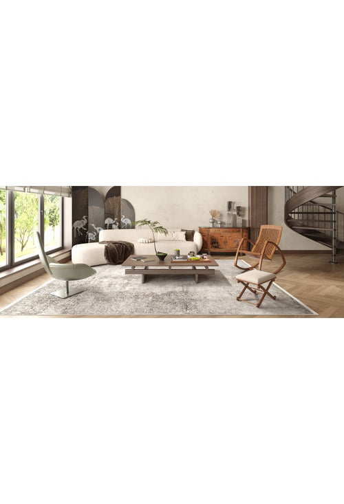 Load image 1 in gallery view. A modern living room with large windows, a white sectional, wooden coffee table, tan chairs, and the Noble Insignia - Washable Rug - JR1830—perfect for high-traffic spaces. Decor features plants, wall art, and a spiral staircase in the background.