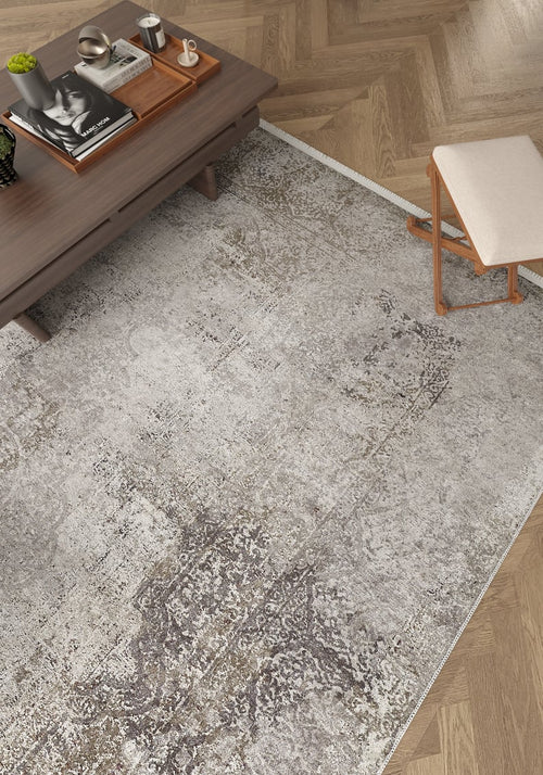 Bild 1 in Galerieansicht laden. A modern living room with the Noble Insignia - Washable Rug - JR1830 (Custom Size) in grey pattern—ideal for high-traffic areas—on a herringbone wood floor, paired with a wooden coffee table and a cushioned wooden stool.