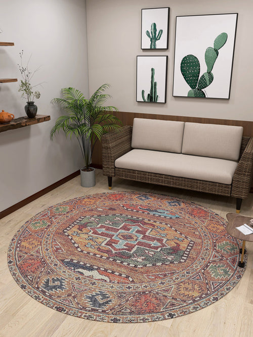Load image 1 in gallery view. A small room features a beige sofa, a plant, and the Nomadic Oasis - Washable Rug - JR5086. Three framed cactus prints hang above the sofa near a wooden shelf decorated with small plants and pottery.