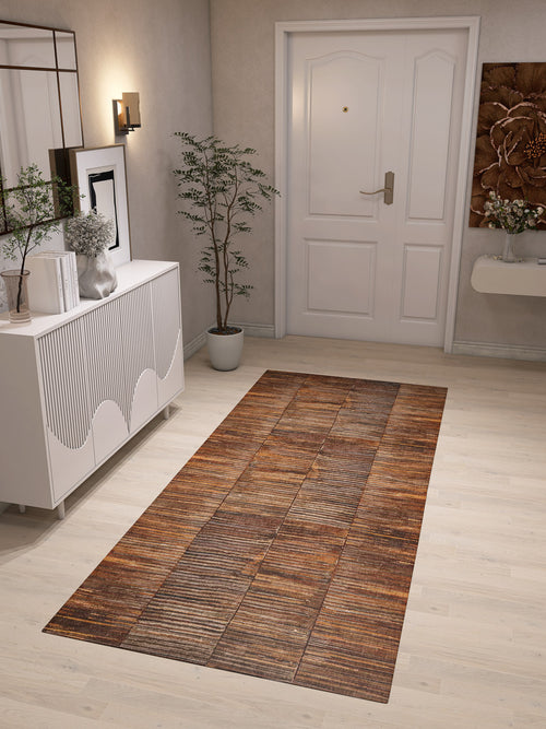 Bild 1 in Galerieansicht laden. A modern entryway features a white door, the Nostalgic Weft - Washable Rug - JRN33 (Custom Size) in a brown pattern on a light wood floor, a white sideboard with decor, potted plant, wall art, and wall-mounted light—ideal for contemporary spaces.