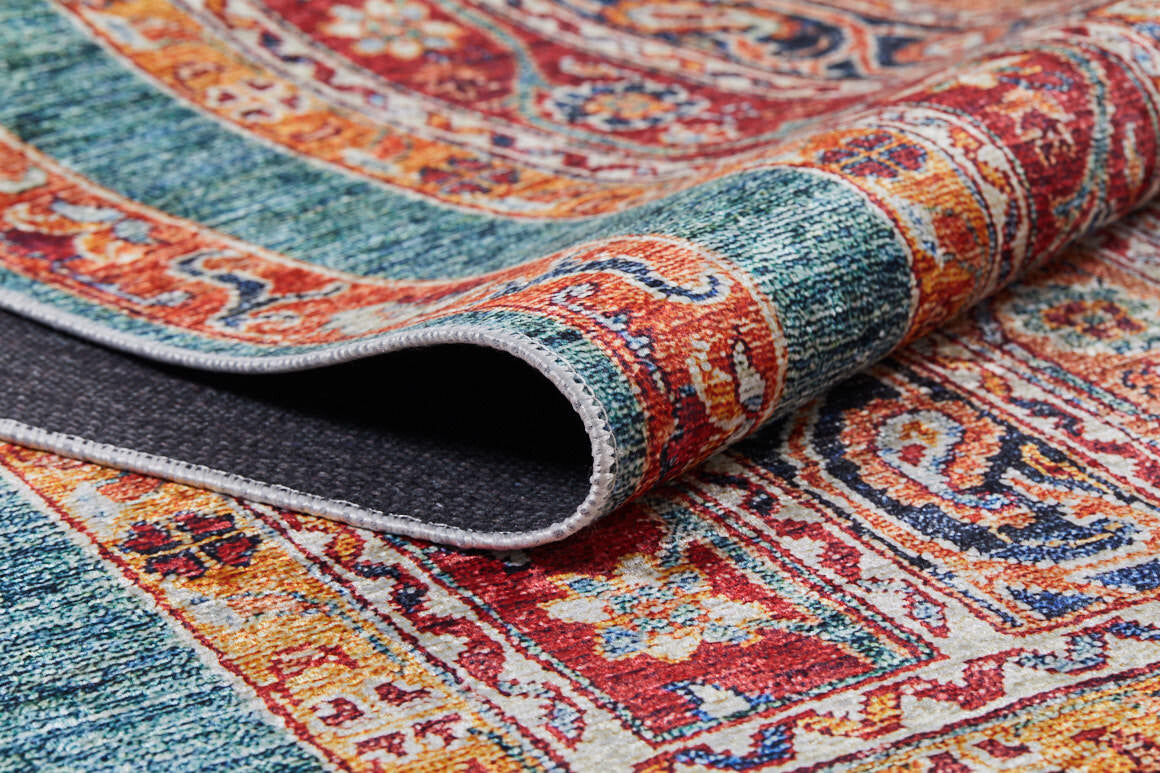 A close-up of the Old-World Elegance - Washable Rug - JR38 (Custom Size), showing its vibrant multicolor red, teal, orange, and yellow flat weave design with a folded corner revealing the dark underside and textured detail.