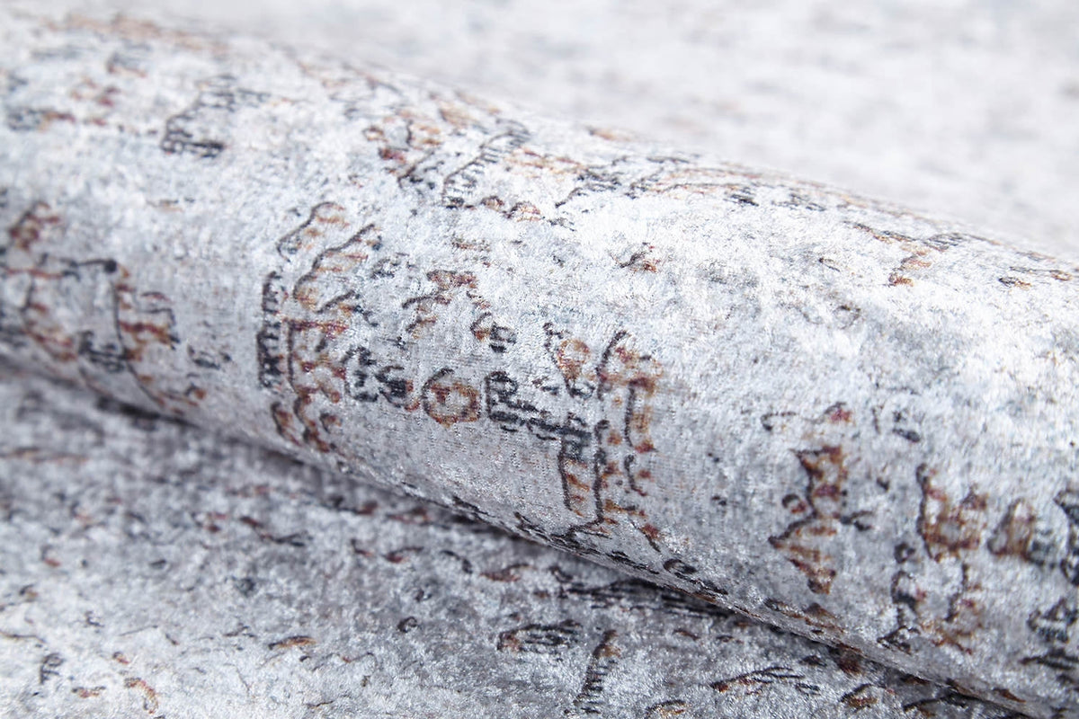 A close-up of the Opulent Tapestry - Washable Rug - JR1775 (Custom Size) shows its textured, silvery gray surface with abstract brown and black markings—an ideal modern flat weave accent.