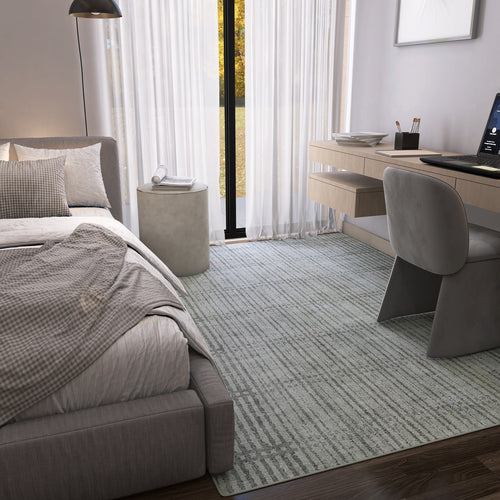 Load image 1 in gallery view. A modern bedroom features a large bed with neutral bedding, desk with computer, gray chair, round side table, and sheer curtains on tall windows. The Ornate Hues - Washable Rug - JRN38 (Custom Size) brings style and convenience to the floor.