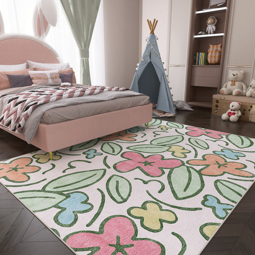 Load image 1 in gallery view. White rug with pastel pink, green, blue, and yellow floral pattern, styled in a child's bedroom.