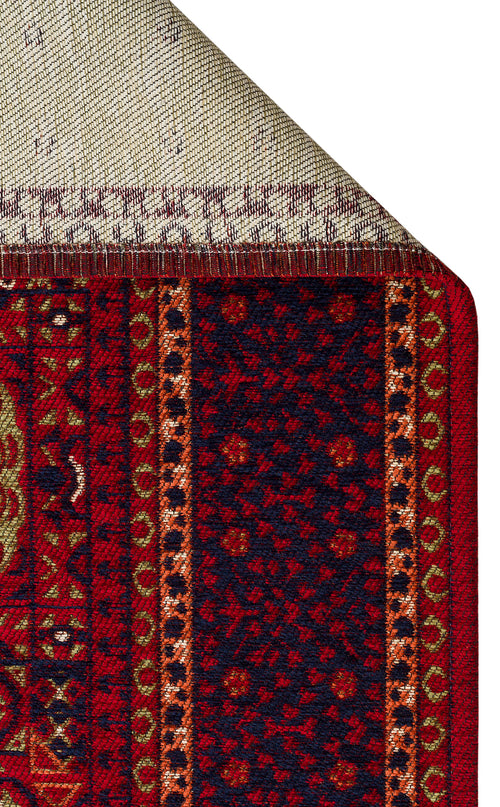 Load image 1 in gallery view. A close-up of the Patch Bloom - Kilim - BHR10 shows its intricate red, navy, and gold geometric patterns, highlighting the detailed weave and stitching on both the front and the folded-over back.