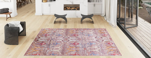 Load image 1 in gallery view. A spacious modern living room with light wood floors, a Peregrine Peachy Brown Washable Rug, a black woven chair, two curved stools, a marble fireplace, and large glass doors leading outside.
