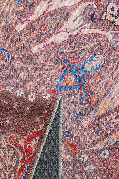 Load image 1 in gallery view. A close-up of the Peregrine Peachy Brown Washable Rug - LCC3022 (Outlet) US shows intricate floral and animal patterns in pink, blue, and cream, with a folded corner revealing its textured, dark grey underside.