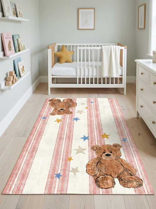 Load image 1 in gallery view. Cream rug with pink stripes, teddy bear motifs, and scattered stars, styled in a nursery.