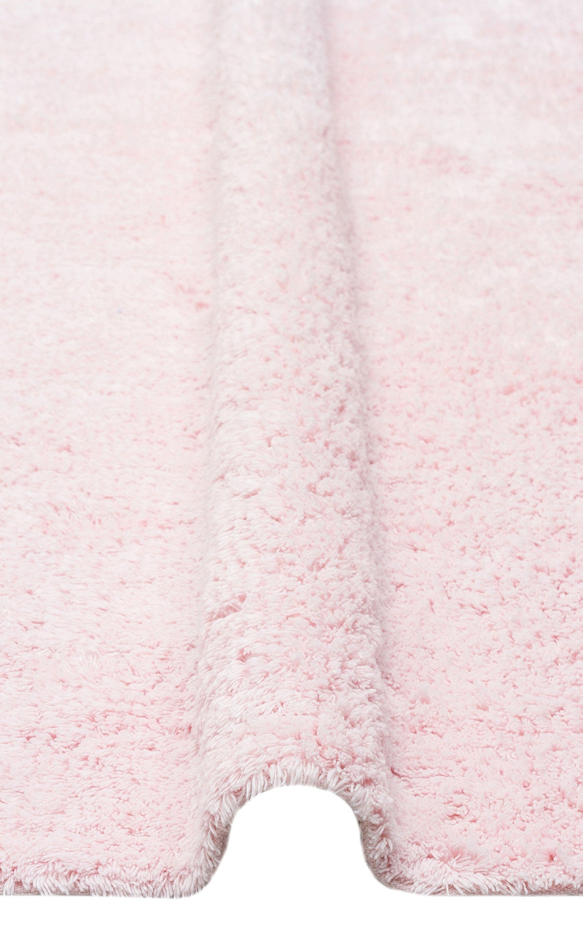 Close-up of the Powder Calm - Washable Shaggy - CBNPLAIN bedroom rug in light pink, featuring a fluffy, textured surface and a raised, folded section running vertically down the center.