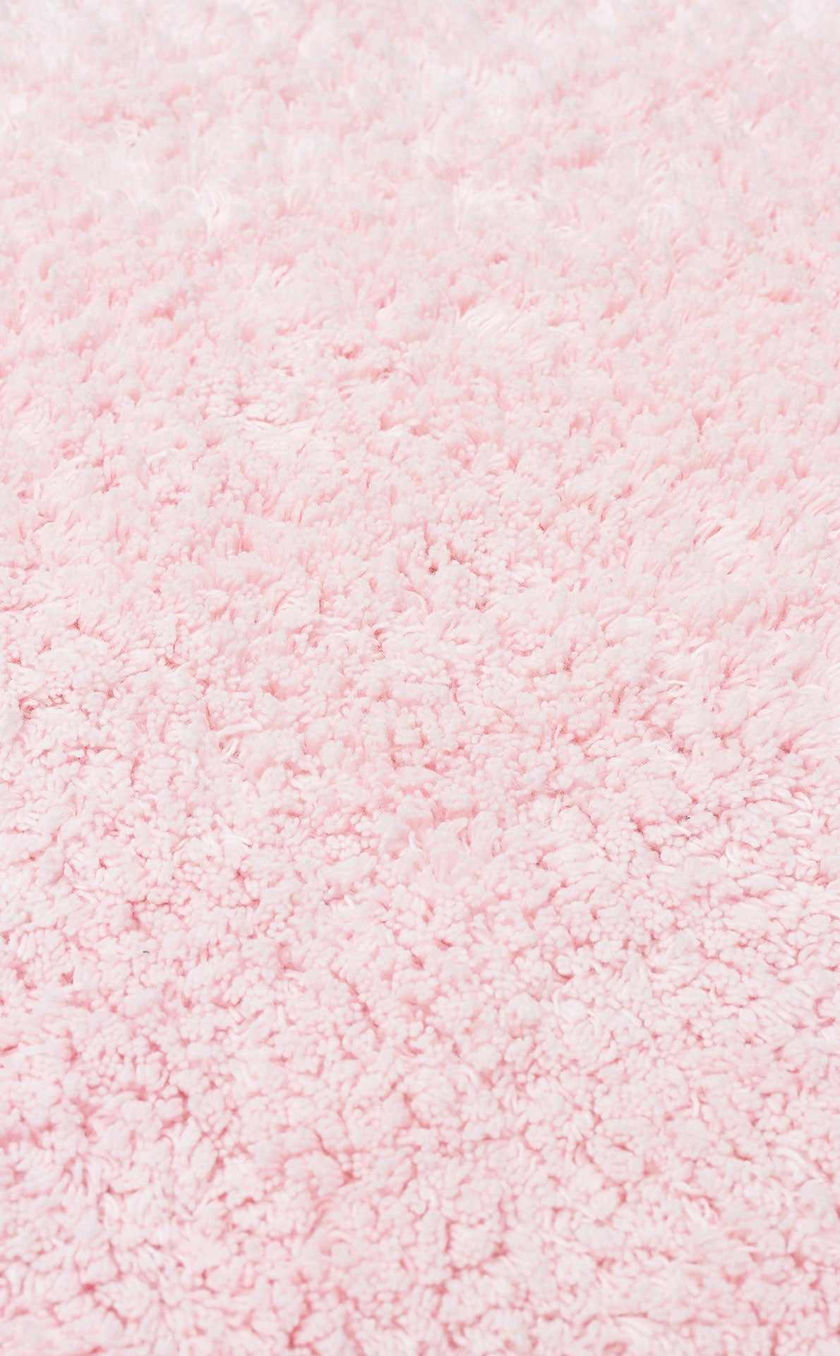 A close-up of the Powder Calm - Washable Shaggy - CBNPLAIN rug highlights its thick, plush light pink fibers—soft, fluffy, and perfect as a washable shaggy accent for a modern bedroom.
