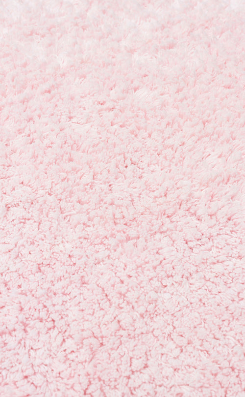 Load image 1 in gallery view. A close-up of the Powder Calm - Washable Shaggy - CBNPLAIN rug highlights its thick, plush light pink fibers—soft, fluffy, and perfect as a washable shaggy accent for a modern bedroom.