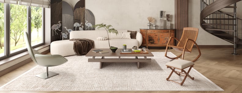 Modern living room with large windows, a white curved sofa, low wooden coffee table, two accent chairs, and a folding screen with crane designs. The Pure Bliss - Washable Rug - JR745 adds warmth and style, perfect for high-traffic, sunlit spaces.