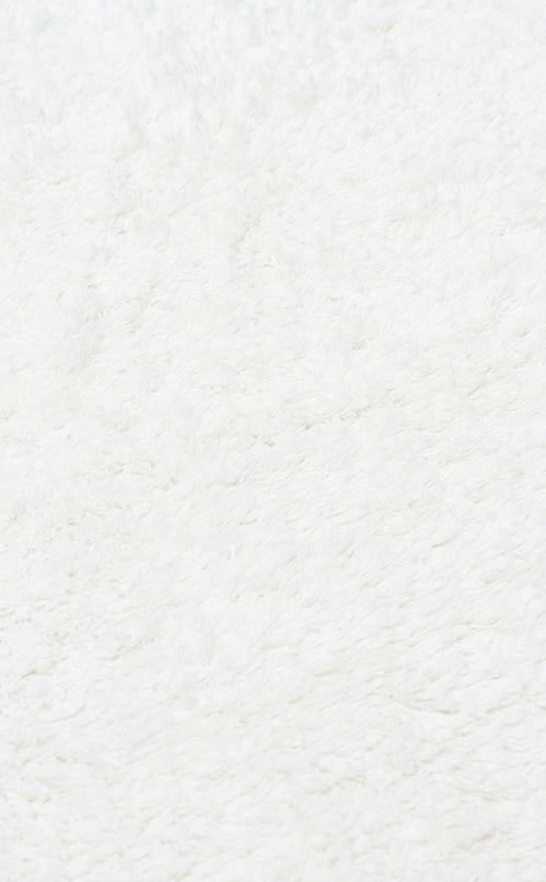 Load image 1 in gallery view. Close-up of the Pure Thread - Washable Shaggy - CBNPLAIN rug, showcasing its soft, white, fluffy texture and plush feel. The clean, even surface features subtle shadows, highlighting this cozy machine-washable cotton rug.