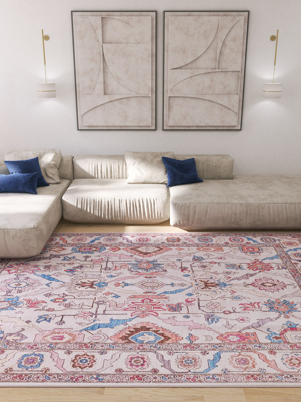 A modern living room with a cream sectional sofa, blue accent pillows, the Quasar Traditional Washable Rug - LCC3024 (Custom Size) for high-traffic areas, abstract wall art, two wall-mounted lamps, and bright natural light.