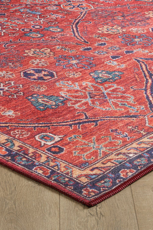 Load image 1 in gallery view. A close-up of the Rhapsody Authentic Red Washable Rug - LCC3033 (Custom Size), featuring intricate multicolor patterns and a geometric border on a light wood floor. Its visible corner highlights its durability, ideal for high-traffic areas.