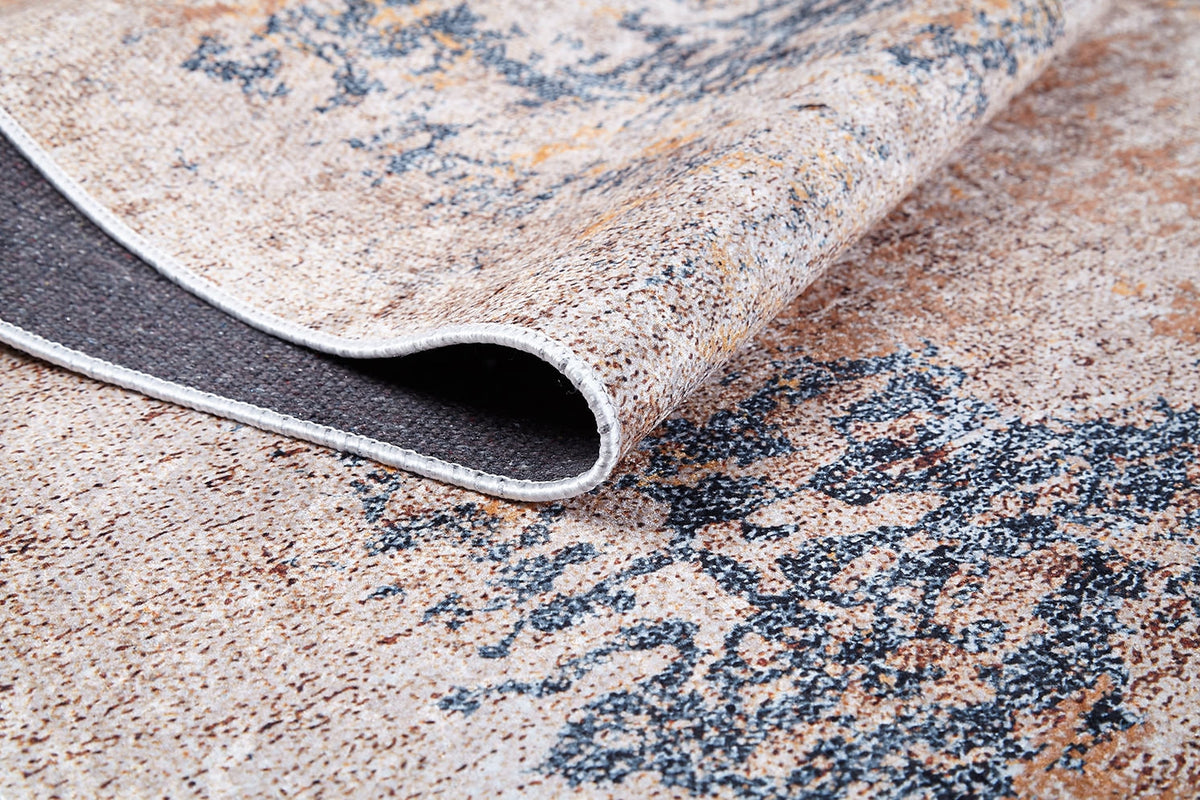 A close-up of the Rhythmic Ripples - Washable Rug - JR1637 (Custom Size) in cream and beige with blue patterns, showing one corner folded to reveal the textured, washable underside.