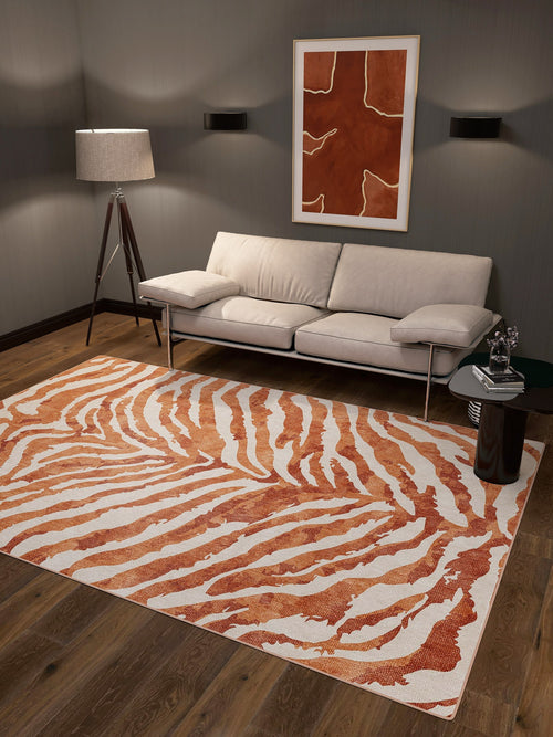 Load image 1 in gallery view. A modern living room with a beige sofa, tripod floor lamp, abstract wall art, a decorated side table, and the Rustic Mirage - Washable Rug - JRN40 featuring an orange-and-white zebra stripe pattern—perfect for high-traffic areas.