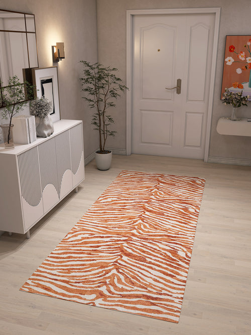 Load image 1 in gallery view. A hallway with light wooden floors features the Rustic Mirage - Washable Rug - JRN40, perfect for high-traffic areas, along with a white dresser, decor accents, a potted plant, wall mirror, artwork, and a closed white door.