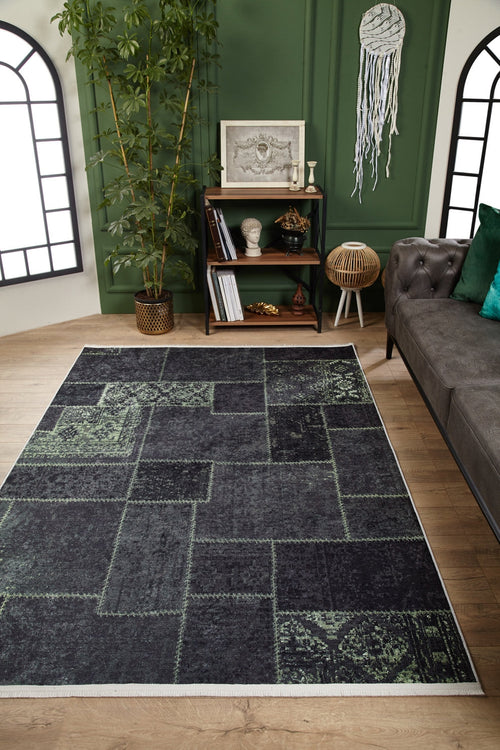 Load image 1 in gallery view. A living room featuring the Rustic Remix - Washable Rug - JR1710 (Custom Size), ideal for high-traffic areas, a gray sofa, small bookshelf with decor, potted bamboo plant, green accent wall with art, light wood floors, and arched windows.