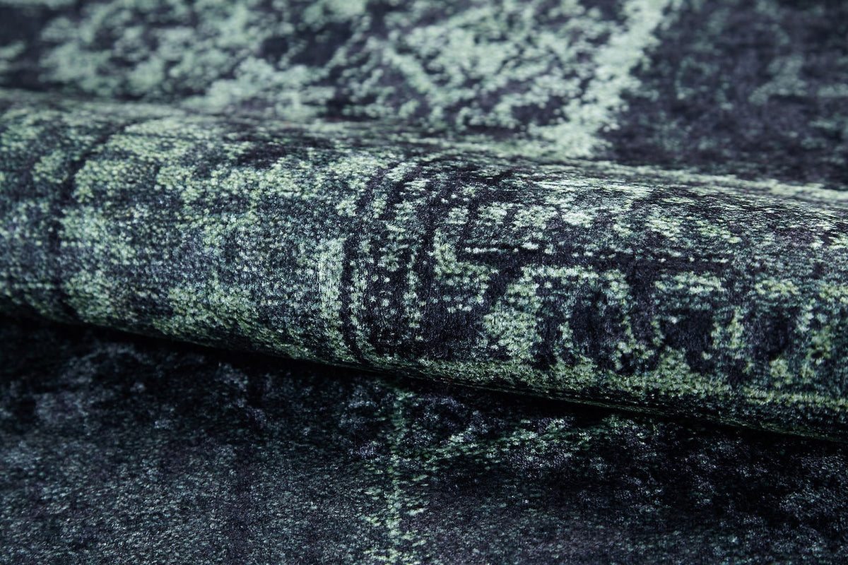 A close-up of the Rustic Remix - Washable Rug - JR1710 (Custom Size) showcases its dark green and black abstract pattern, textured surface, and durability—perfect for high-traffic areas.