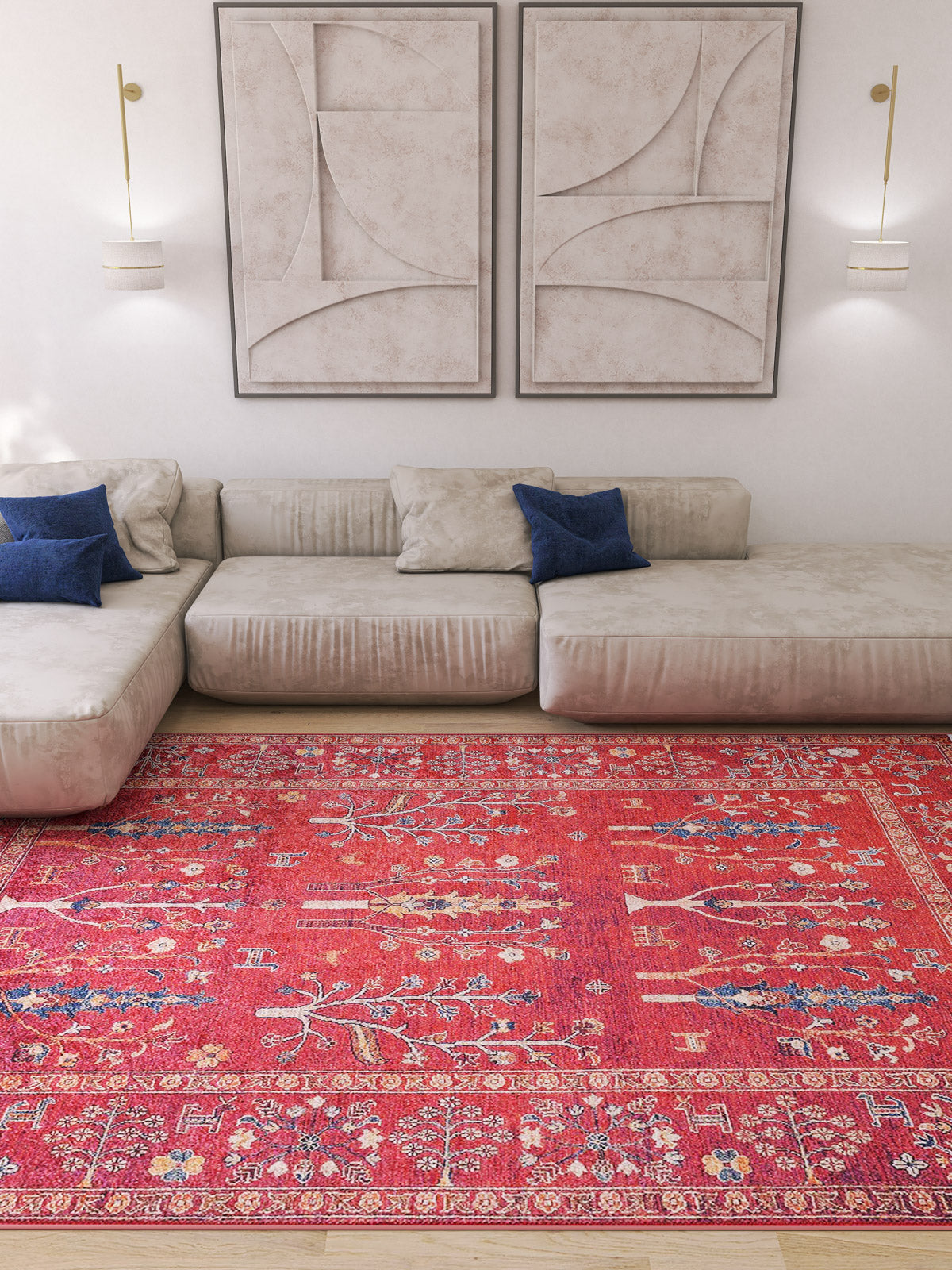 A modern living room featuring the Rustic Retreat - Washable Rug - JR5095 (Custom Size) in red pattern, ideal for high-traffic areas, plus a beige sectional with blue and beige pillows, abstract wall art, and two wall-mounted lights on a white wall.