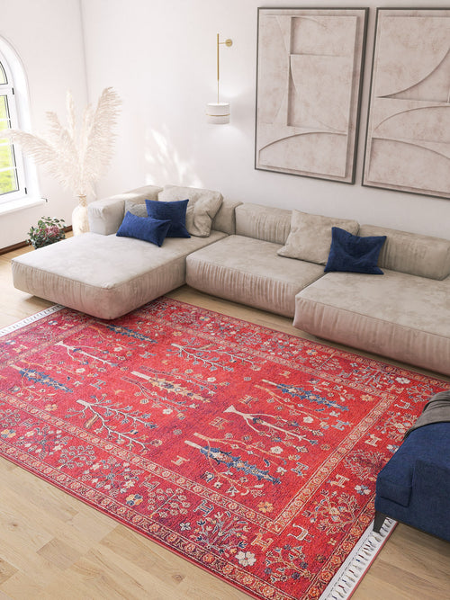 Load image 1 in gallery view. A modern living room with a large beige sectional, blue pillows, abstract wall art, and the vibrant Rustic Retreat - Washable Rug - JR5095 (Custom Size), perfect for high-traffic areas, plus natural light and pampas grass in the corner.