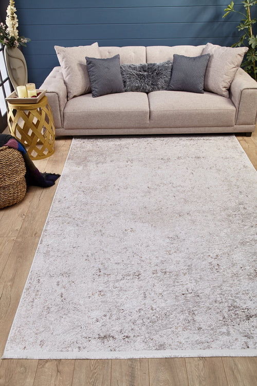 Load image 1 in gallery view. A cozy living room with a beige sofa, gray and cream pillows, a fluffy cushion, and the Rustic Trails - Washable Rug - JR1736 (Custom Size) perfect for high-traffic areas, plus a yellow side table, candles, plants, blanket basket on wooden flooring.