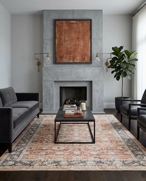 Load image 1 in gallery view. Modern living room with grey walls, concrete fireplace, abstract art, dark sofas, black coffee table with books and candles, Rustic Bloom - Area Rug - APX2961, wall sconces, potted plant, and large light curtains.