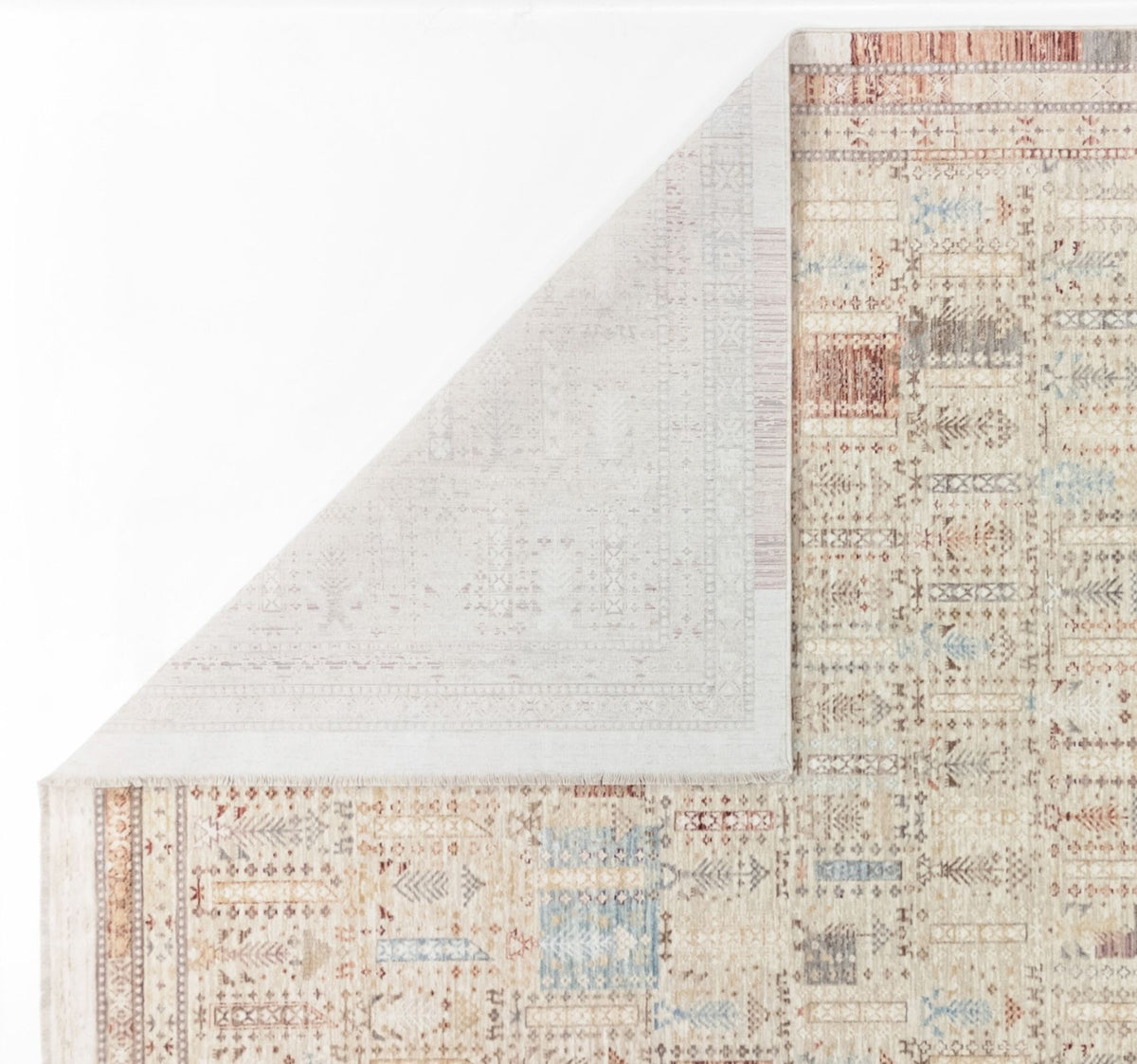 Beige area rug with a multi-colored geometric pattern and a folded corner revealing the light-colored backing.