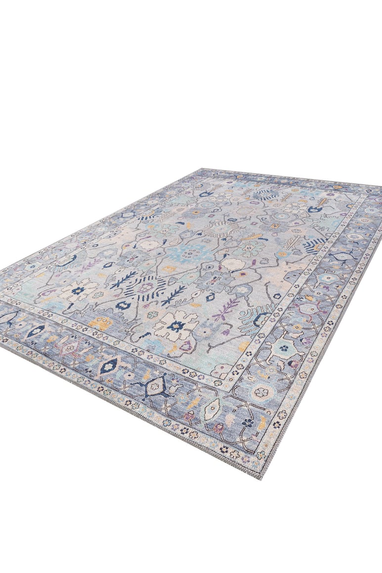 The Seraphix Pastel Bordered Washable Rug - LCC3011 features a large blue design with pale blue, gray, and cream background, intricate floral and geometric patterns in blue, yellow, and purple—ideal for high-traffic areas with a detailed matching border.