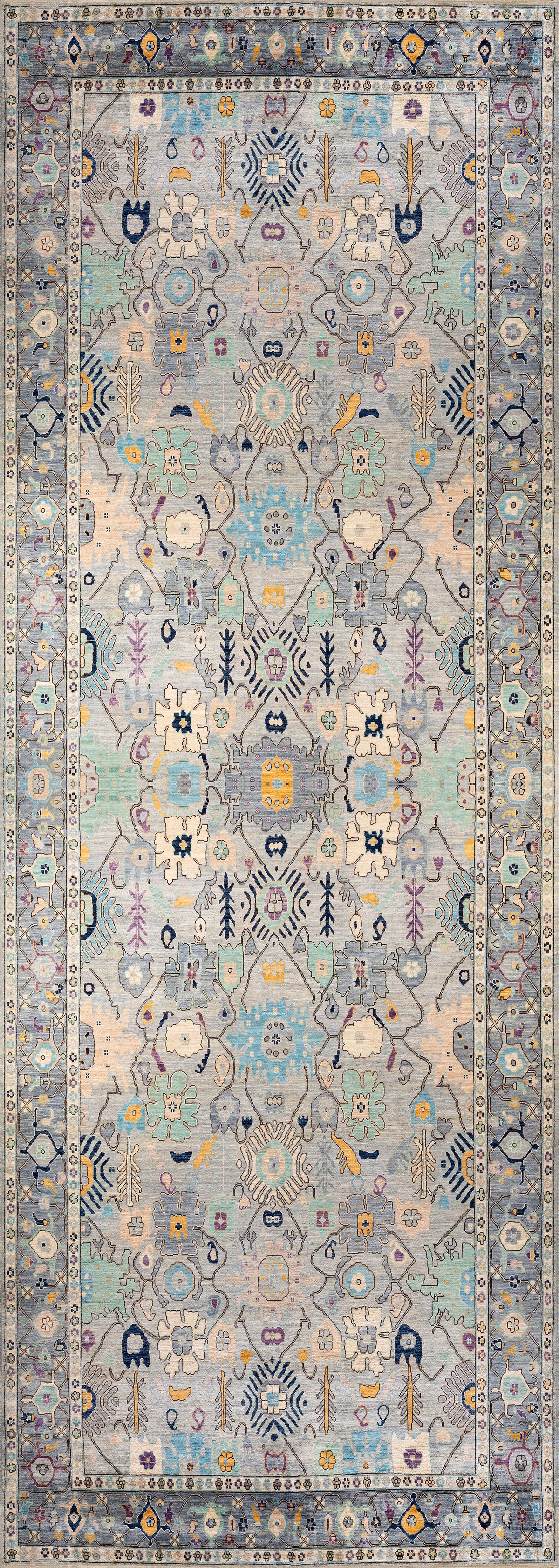 The Seraphix Pastel Bordered Washable Rug - LCC3011 features intricate symmetrical floral and geometric patterns in pastel blue, yellow, and cream with a detailed repeating border, ideal for high-traffic spaces.