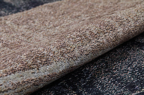 Load image 1 in gallery view. Close-up of the Serene Swirls - Washable Rug - JR952 (Custom Size) in bronze and brown, featuring a beige, brown, and cream speckled pattern—ideal for high-traffic areas, shown rolled up on a coordinating textured dark surface.