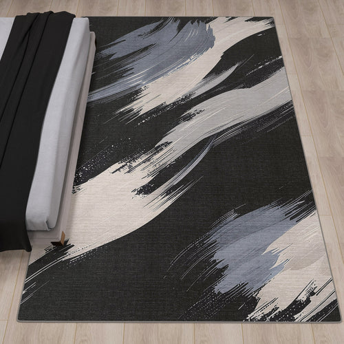 Load image 1 in gallery view. The Shadow Flow - Washable Rug - JRS011 (Custom Size) features abstract black, gray, and white brushstroke patterns and is ideal for high-traffic areas, shown here on a light wood floor beside a neatly made bed.