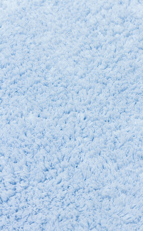Load image 1 in gallery view. Close-up of the Sky Nap - Washable Shaggy - CBNPLAIN rug in soft blue cotton, featuring thick, textured fibers for a cozy, inviting touch.