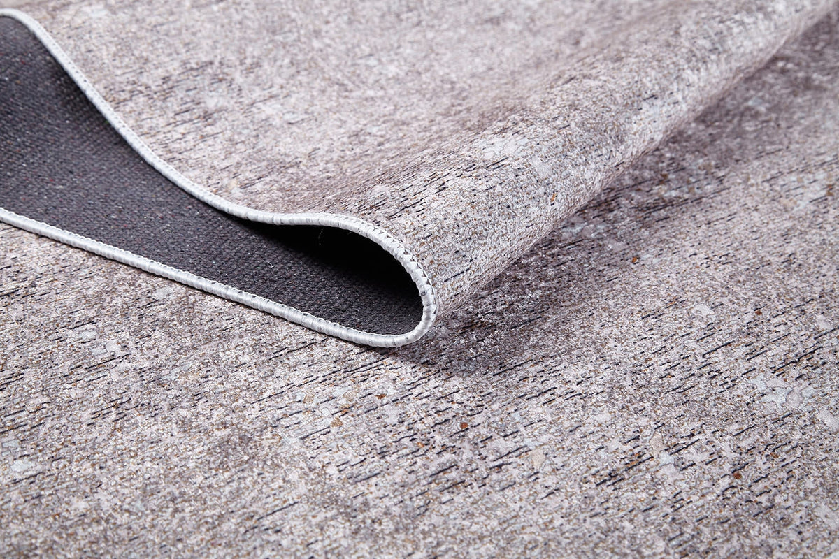 A close-up of the Slate Charm - Washable Rug - JR1740 (Custom Size) in cream and beige, featuring a textured stone pattern, flexible design, and dark backing—ideal for high-traffic spaces.