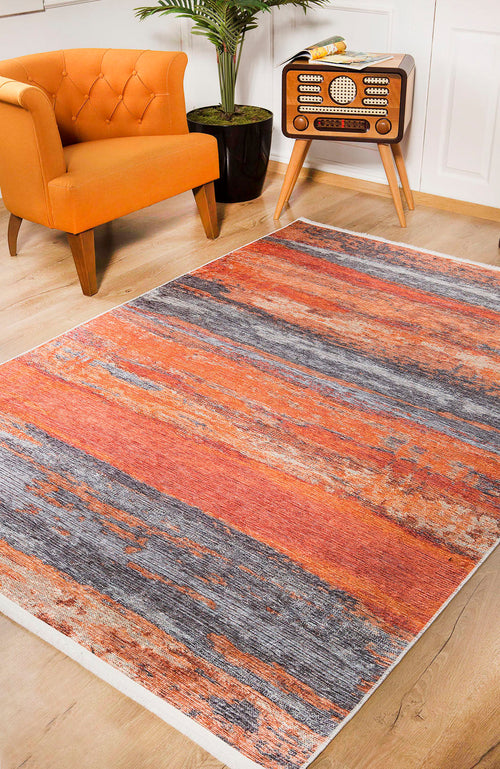 Load image 1 in gallery view. The Sleek Brushed - Washable Rug - JR431 (Custom Size), with orange, blue, and gray stripes, brightens wooden floors beside an orange armchair and plant—ideal for high-traffic areas and modern decor.