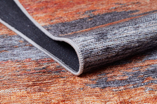 Load image 1 in gallery view. A close-up of the Sleek Brushed - Washable Rug - JR431 (Custom Size) shows its textured surface in orange, brown, and gray with a stitched border, perfect for high-traffic areas. One edge is lifted to display the underside.