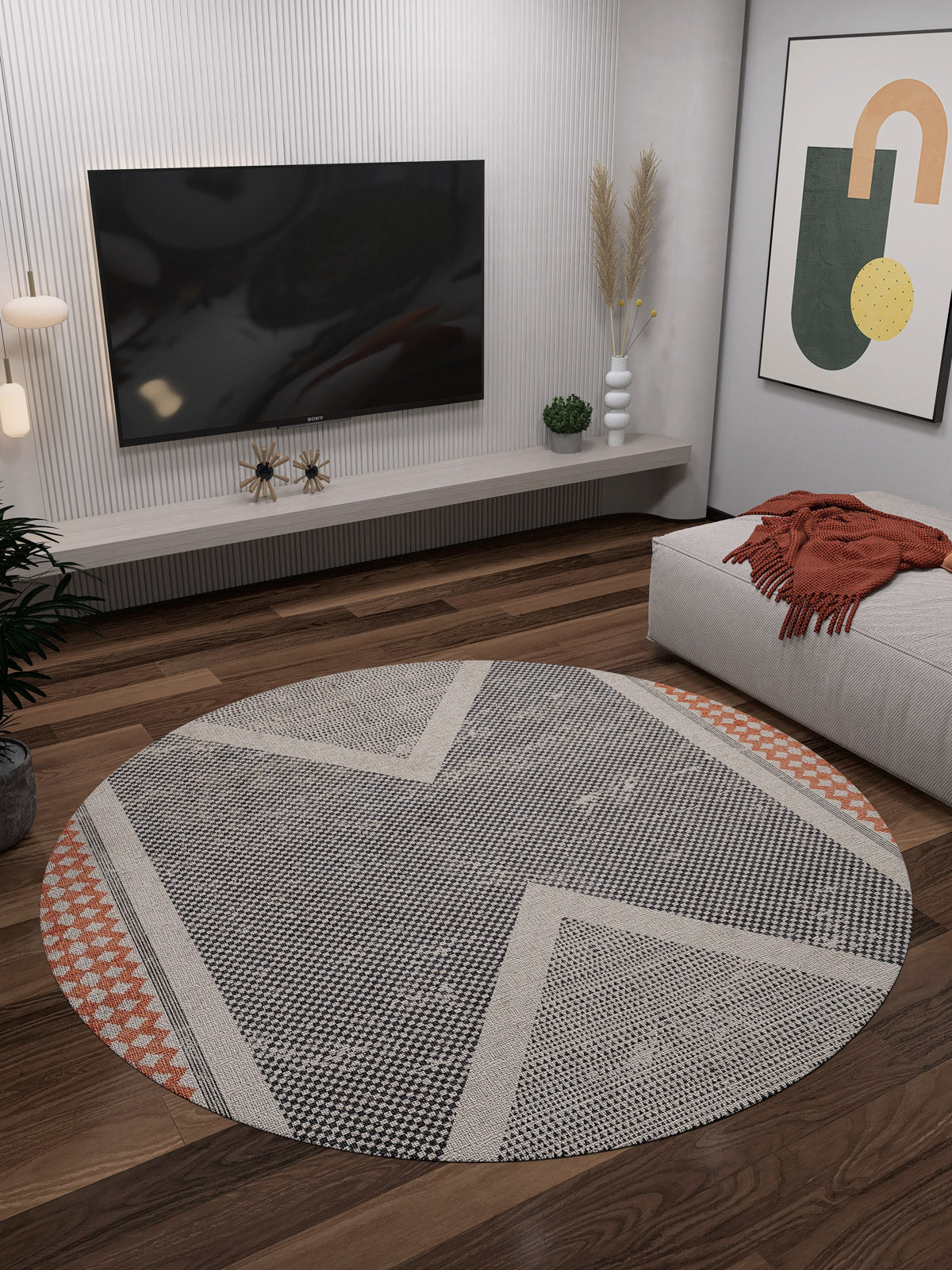 A modern living room featuring the Sleek Design - Washable Rug - JR1727, perfect for high-traffic wooden floors, with a wall-mounted TV, floating console, abstract art, a gray ottoman with an orange throw, and stylish plants and decor.