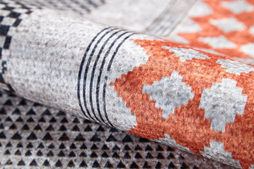 Load image 1 in gallery view. A close-up of the Sleek Design - Washable Rug - JR1727 (Custom Size), showcasing geometric patterns with black and white triangles, orange and gray diamonds, and parallel black lines—perfect for allergy-sensitive homes.