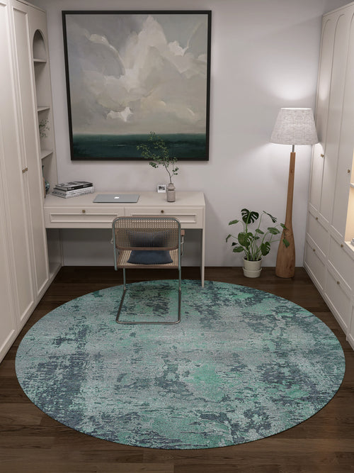 Load image 1 in gallery view. A home office with a white desk, laptop, wicker chair, Smokey Mountains - Washable Rug - JR1631 in green, potted plant, tall floor lamp, bookshelves, and large abstract painting—great for high-traffic areas.