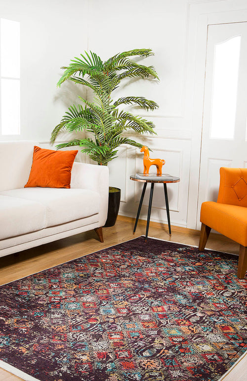 Bild 1 in Galerieansicht laden. A living room featuring the Soft Haze - Washable Rug - JR1094 (Custom Size) for high-traffic areas, a white sofa with an orange pillow, orange armchair, small round table with an orange horse figurine, potted plant, and white walls.